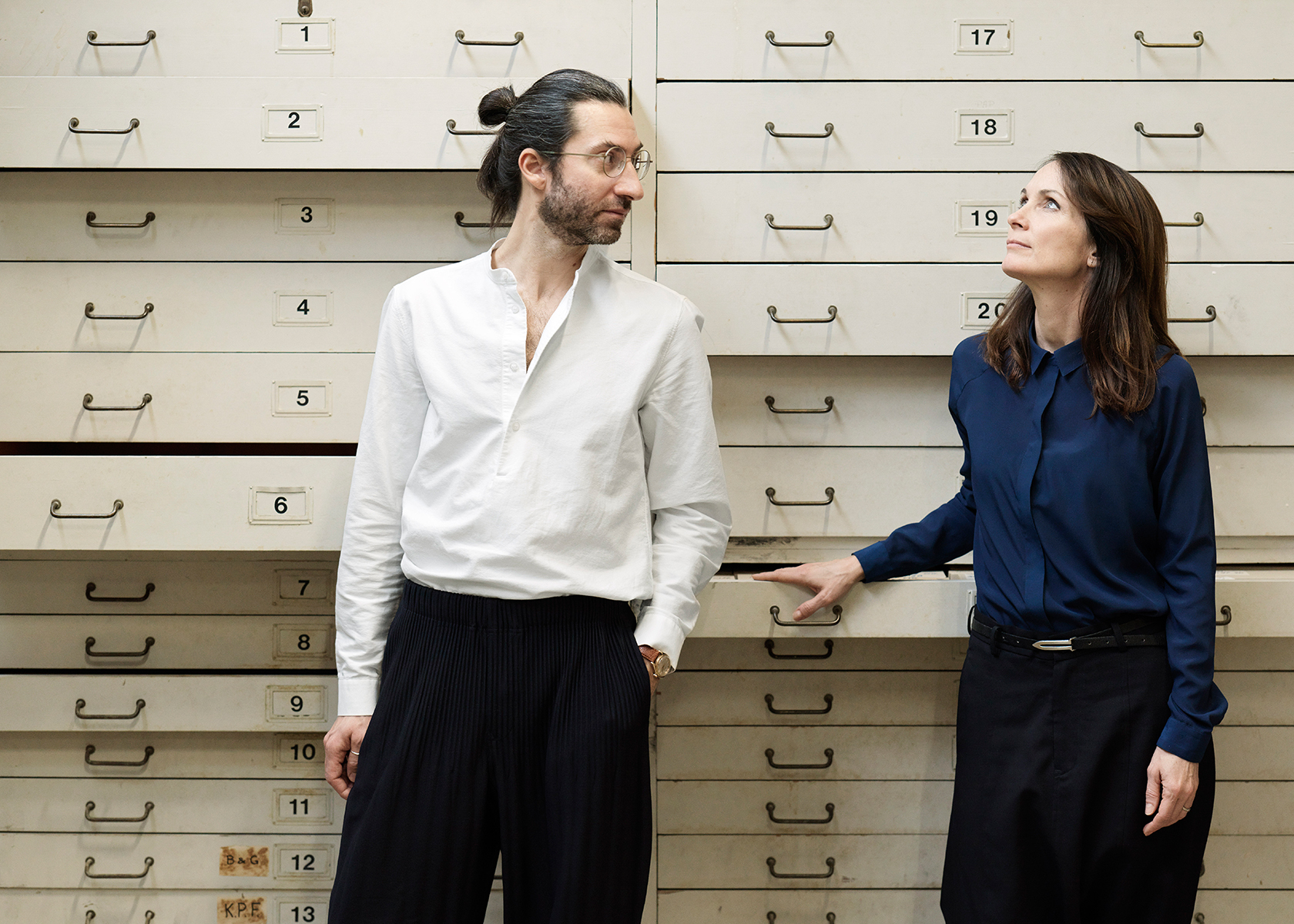 The designers GamFratesi standing in front of a lot of drawers